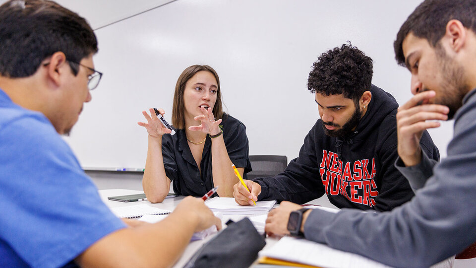 students in classroom at table with notebooks