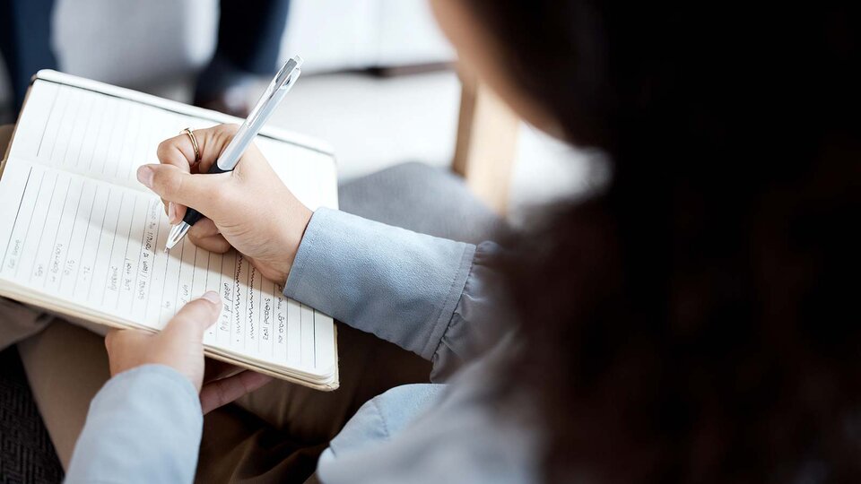 person documenting issues in a notebook