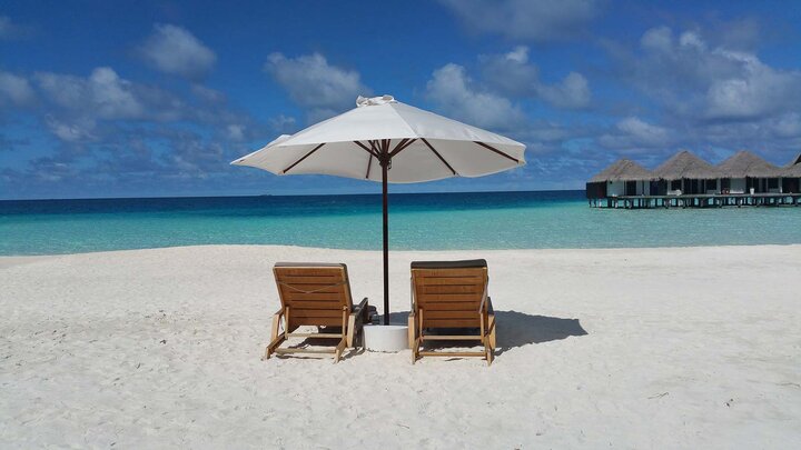 chairs under umbrella on a beach