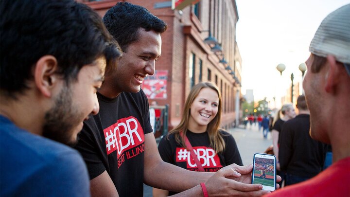 A group of students in the Haymarket looking at a picture on a phone