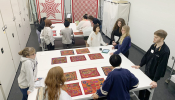 Students from the University of Nebraska–Lincoln and Saitama University work with a collection of molas at the International Quilt Museum.
