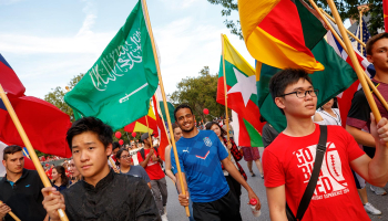 international students in homecoming parade holding country flags